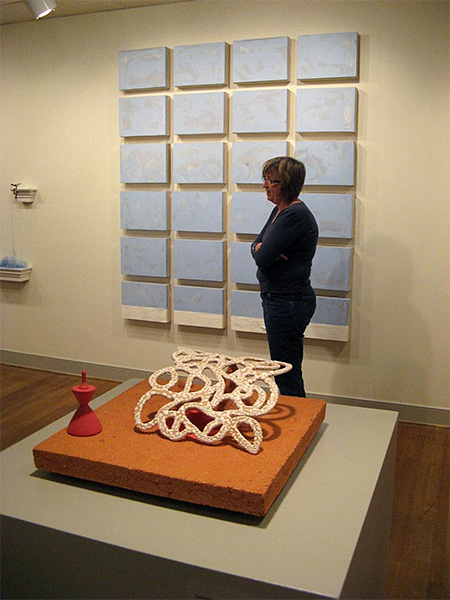 Carol Garmon standing in front of Sewing Bird, the marriage bed and “crisp sheet.”
