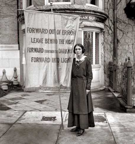 Suffragist holding a banner at the memorial for Inez Milholland Boissevain.