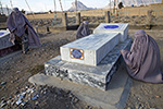 Roya Shams (right) gently weeps alongside her mother and sister as she bids farewell to her father in a Kandahar cemetery. 