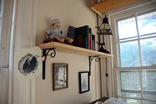 Doll, books, raven fan, and framed images.