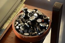 Bowl of push pins with typewriter key style heads.