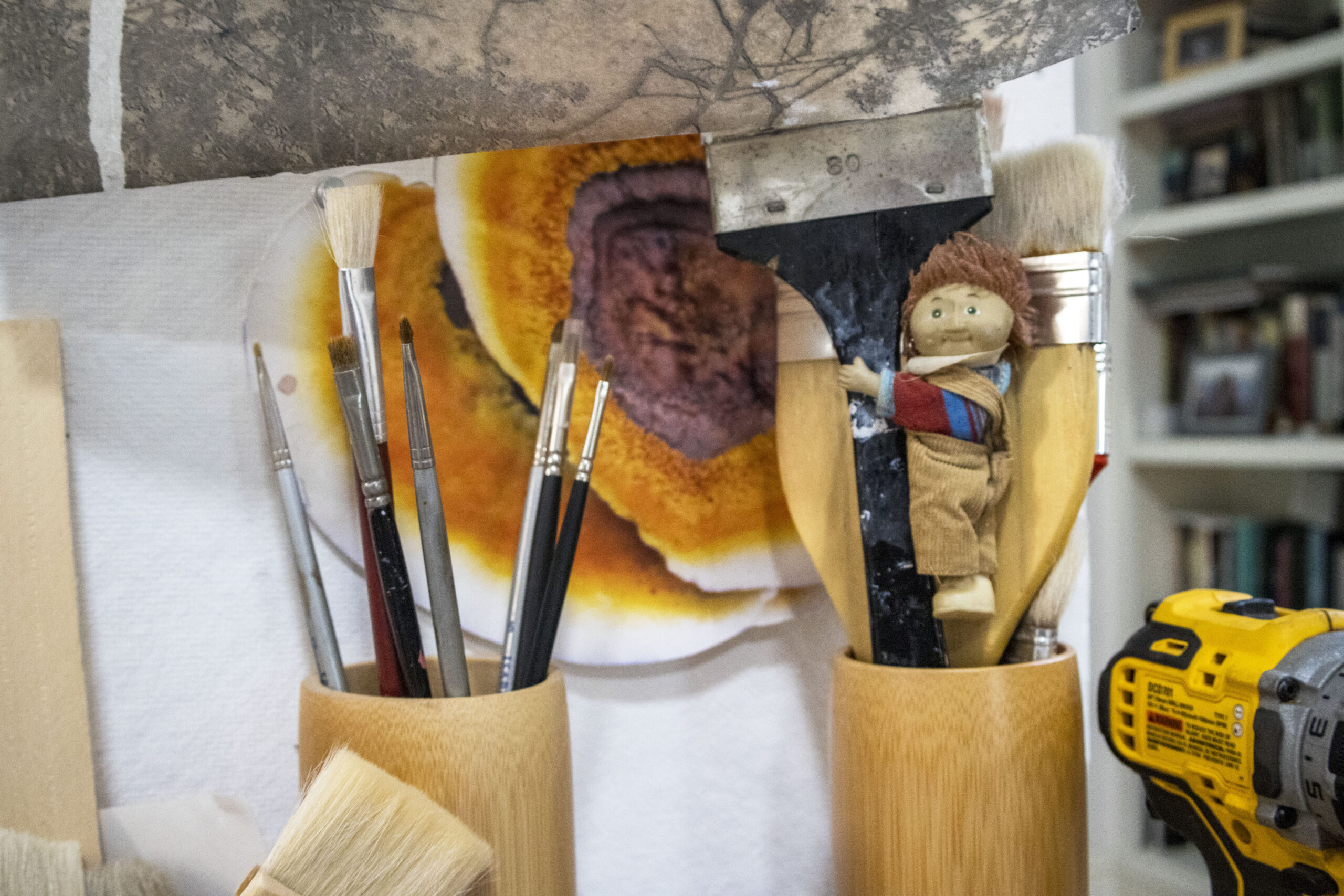 A close-up of two cups holding paintbrushes.