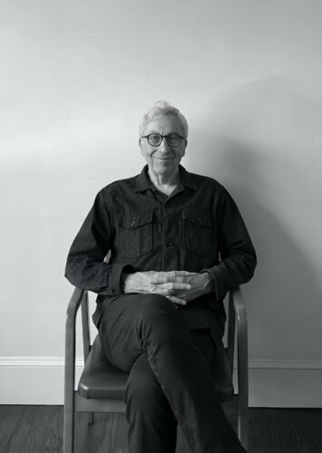 Photo of artist Cliff Tisdell seated and smiling.