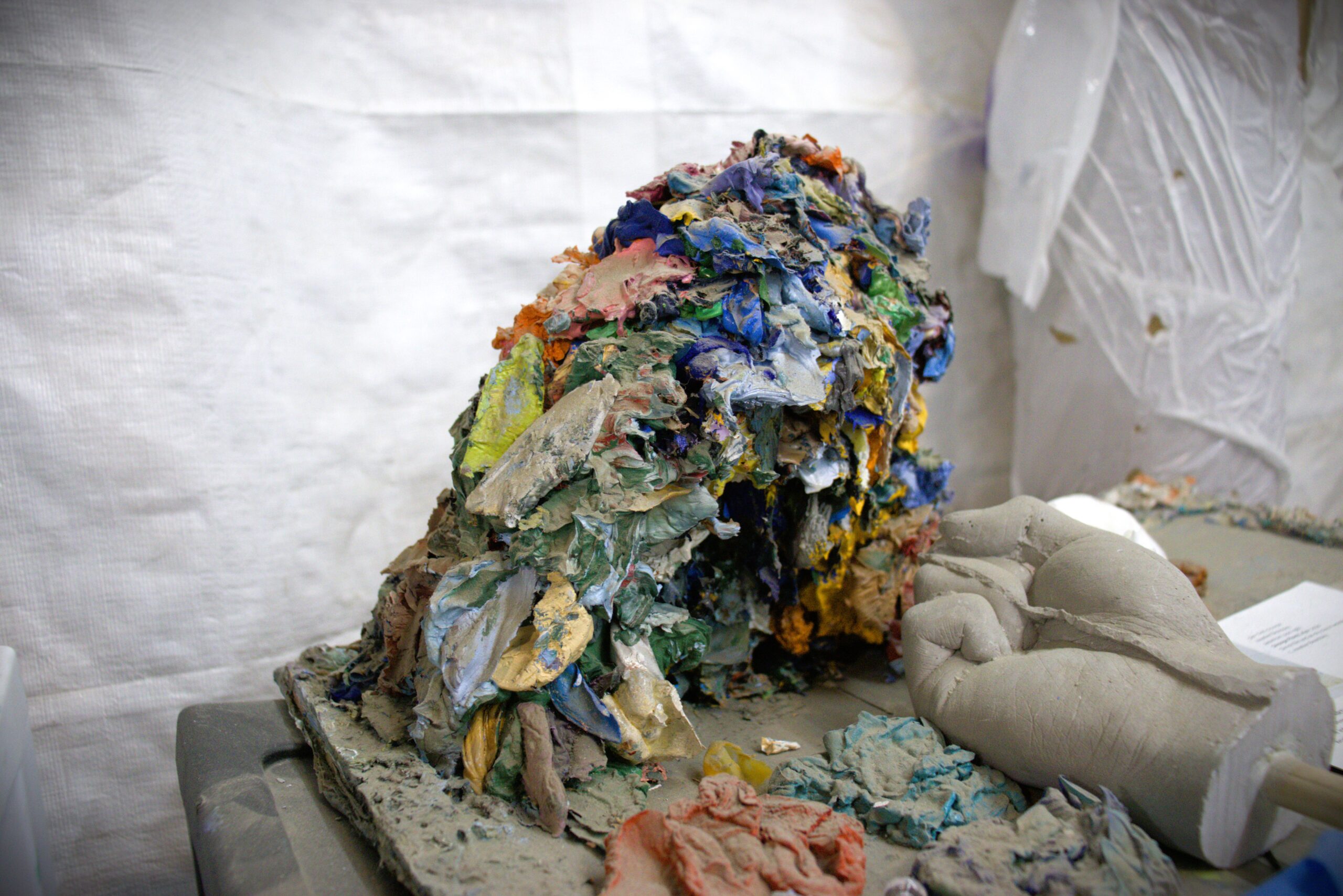 Many globs of used paint piled on top of each other to create a mound.
