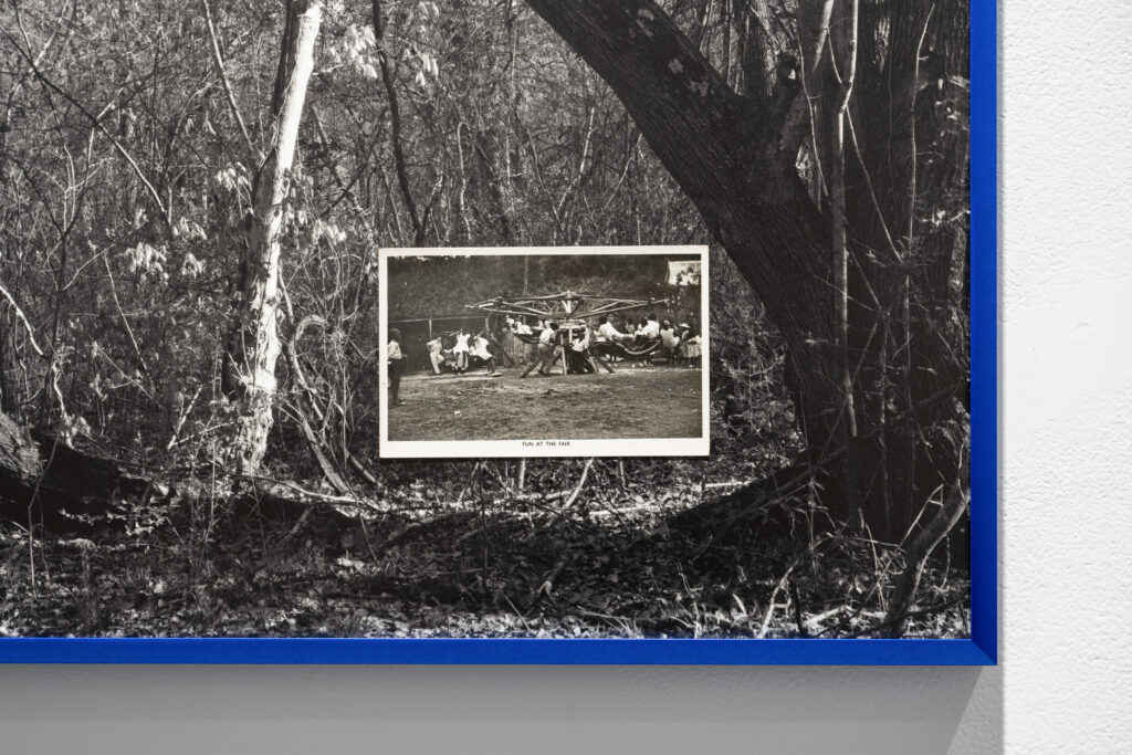 Close-up of postcard that is captioned "FUN AT THE FAIR" showing people on a swing, placed on top of a photo of the woods