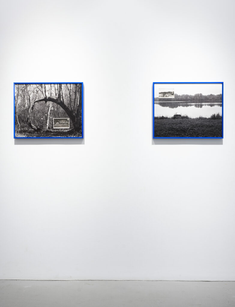 Two images hung together, with space between them, on white wall. Both are black-and-white photographs of landscapes framed in blue, which include black-and-white postcards on top of them.